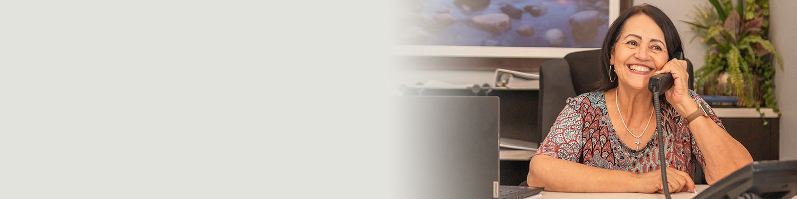 a receptionist smiling and on the phone at the front desk at Gateway